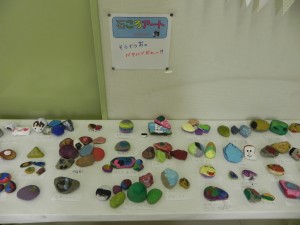色とりどりの出来上がった作品が並べて展示されている石ころアートの写真