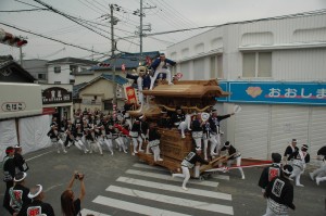 だんじり曳行する法被姿の人たちの写真