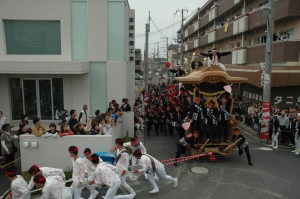 だんじり曳行する法被姿の人たちの写真