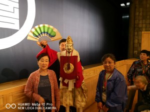淡路人形座観劇の参加者と実際に人形劇で使われた人形と演者による記念写真