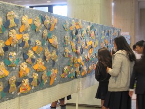 こども文化祭こども作品展で東忠岡小学校1年が作った作品を眺める来場者たちの写真