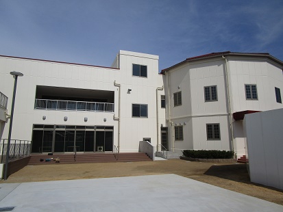 白い壁の二階建ての建物の外観写真