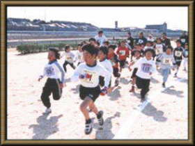 グラウンドを走るたくさんの子どもたちの写真