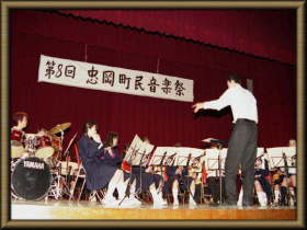 第5回忠岡町音楽祭と書かれた舞台の上で演奏している人たちの写真